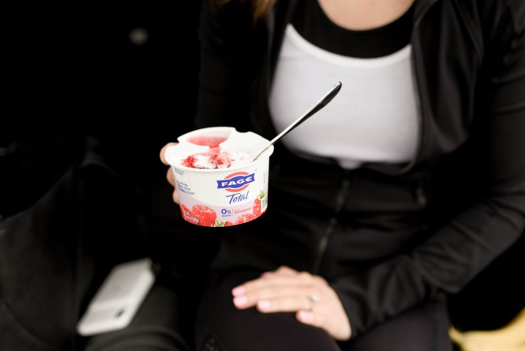 A woman sitting in a car with yogurt