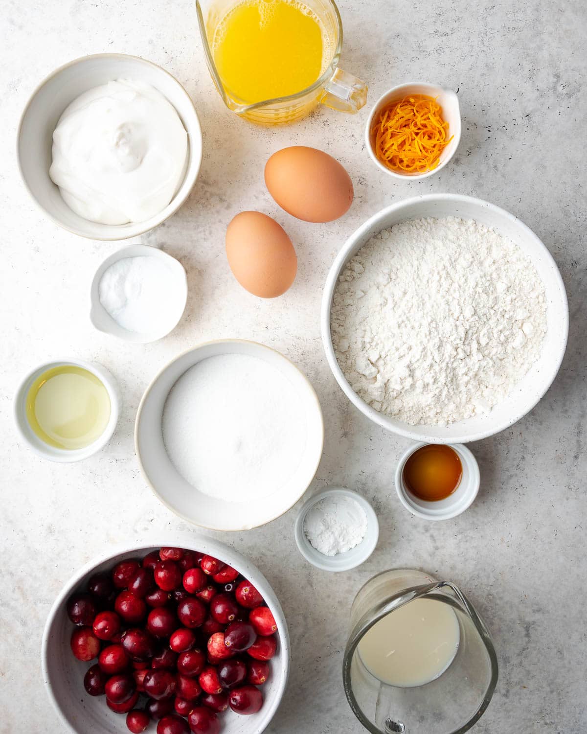 ingredients in glass bowls needed to make an orange quick bread