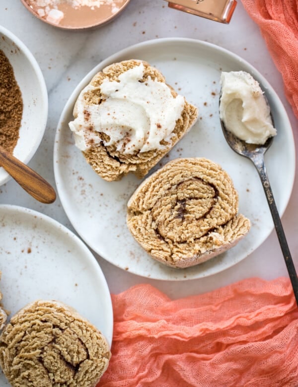 cinnamon rolls on a white plate with frosting