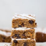 carrot cake bars with icing on parchment paper