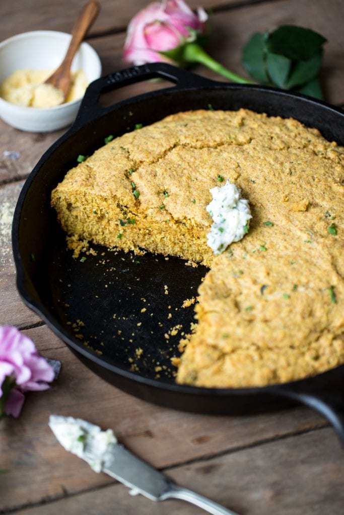 cornbread in a skillet with herb butter