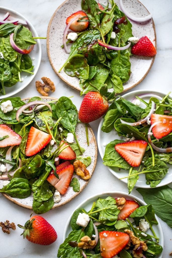strawberry spinach salad on white plates