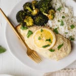 chicken breast on a white plate with roasted broccoli, white rice and a gold fork