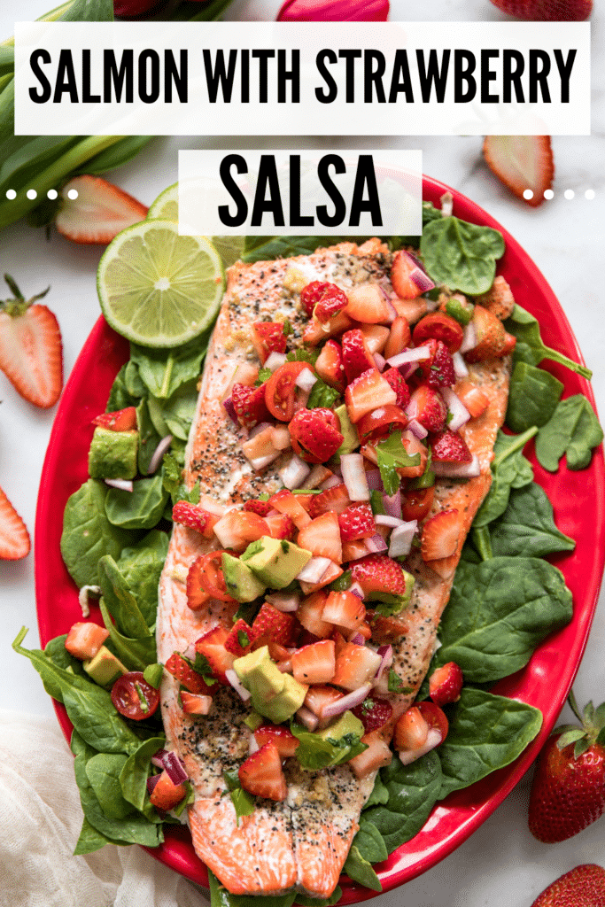 salmon on a bed of spinach on a red plate