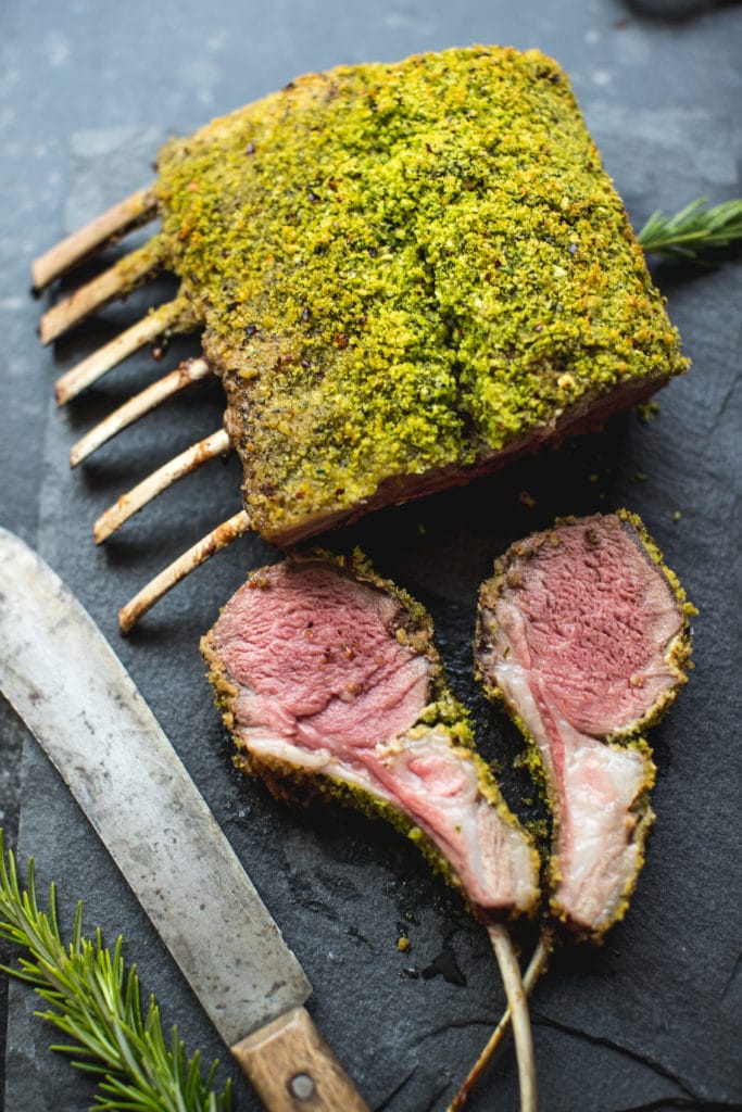 herb crusted rack of lame on a dark blue plate