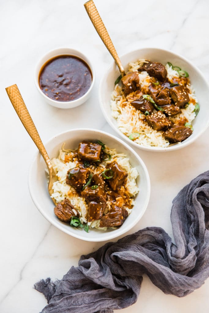 teriyaki slow cooker steak bites in a white bowl with rice