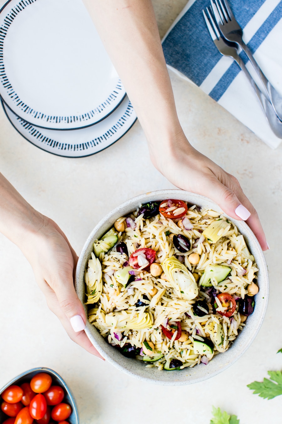 The best orzo salad tossed with a greek dressing in a large bowl ready to be served