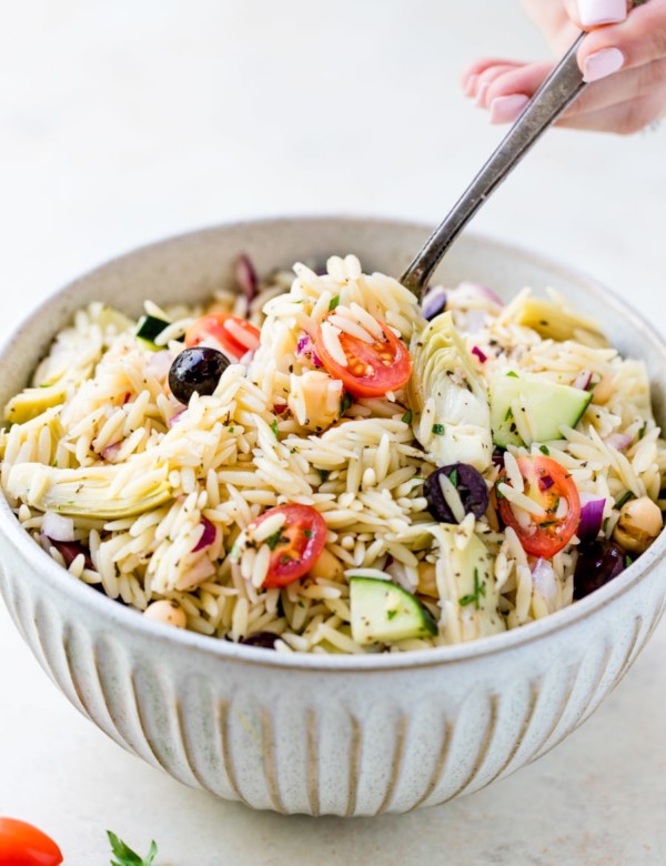 greek orzo pasta salad in a large white bowl