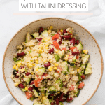 quinoa in a bowl with fresh veggies and a tahini lemon dressing