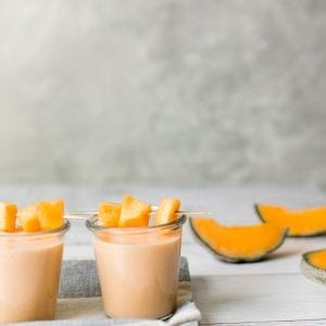 a melon smoothie in a glass jar on a wood board