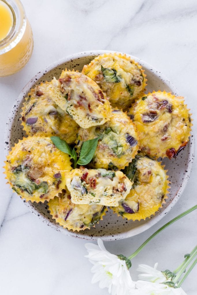 sun dried tomato eggs muffins on a white speckled plate