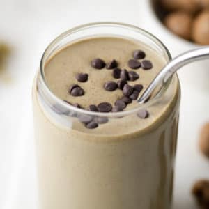 a smoothie in a glass cup garnished with chocolate chips