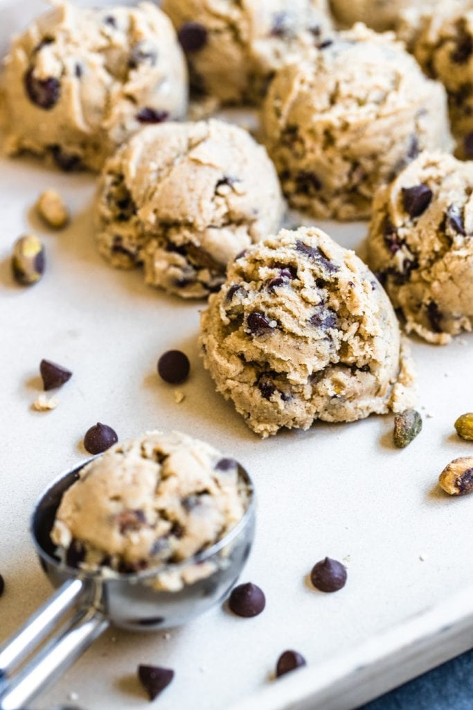 chocolate chip cookie dough with pistachios and cranberries on a baking sheet