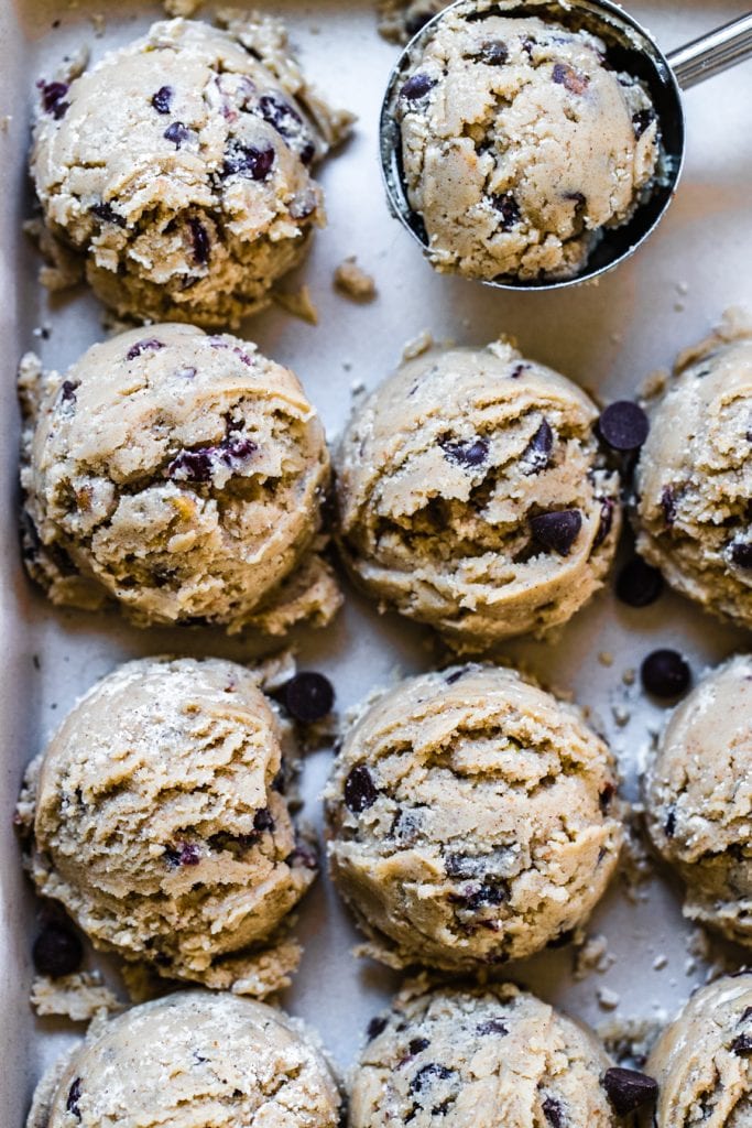 chocolate chip cookie dough with pistachios and cranberries on a baking sheet