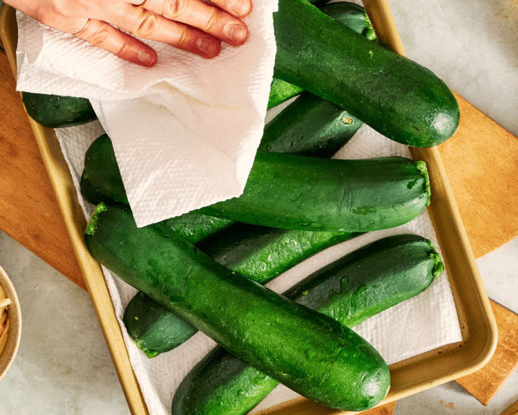 Patting the zucchini dry as it drains on a paper towel before adding it to 9x13 pan.