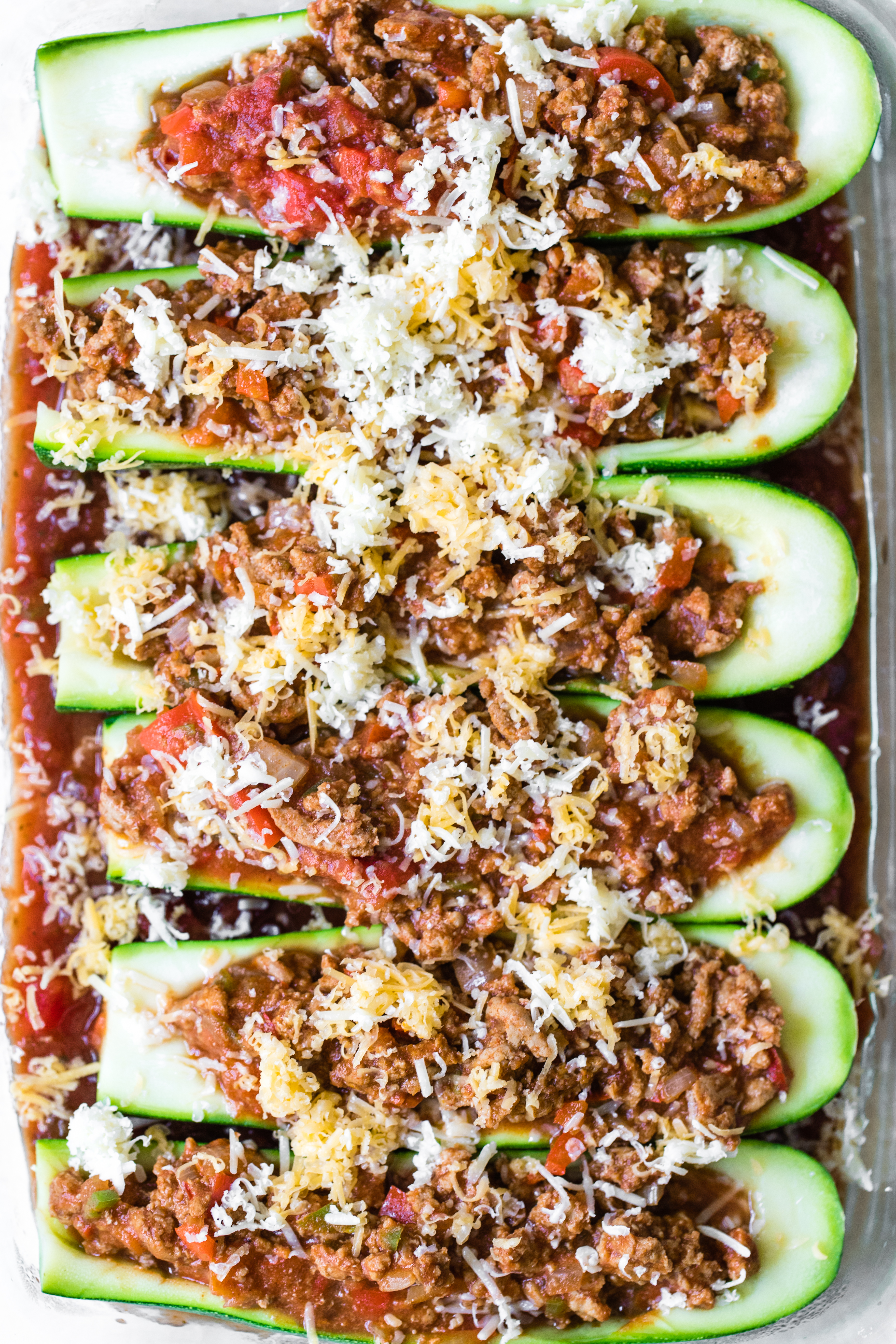 zucchini taco boats in a glass Pyrex dish topped with cheese