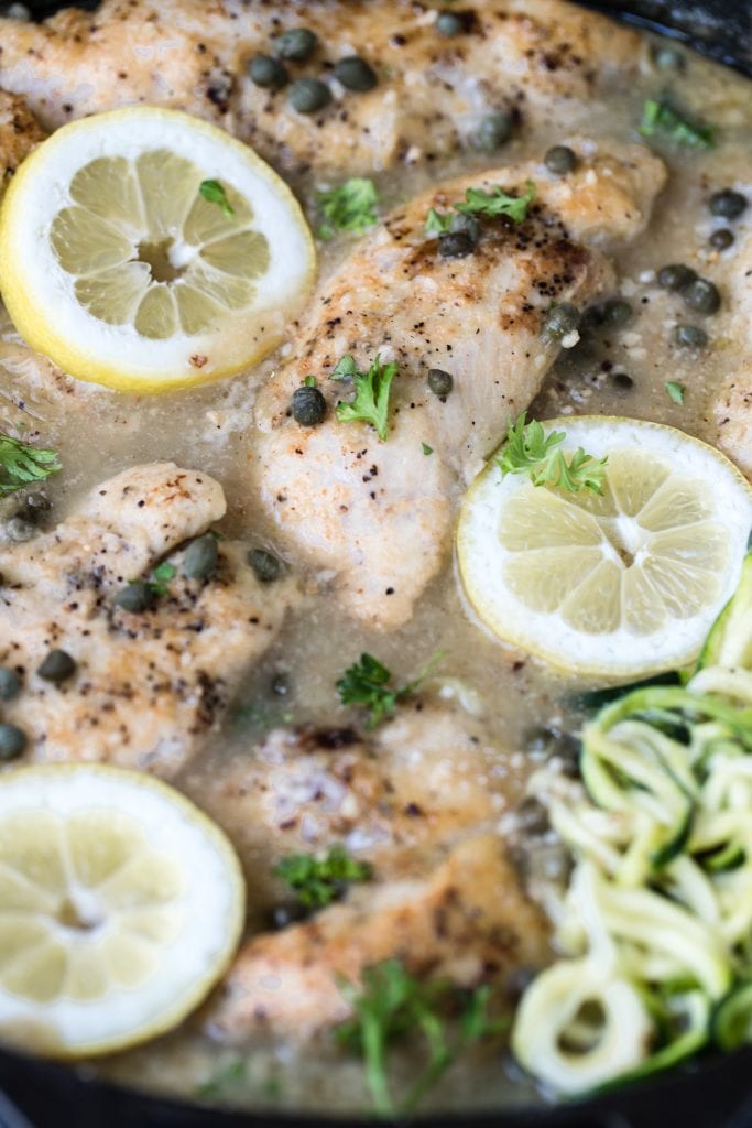 lemon chicken piccata in a cast iron garnished with capers