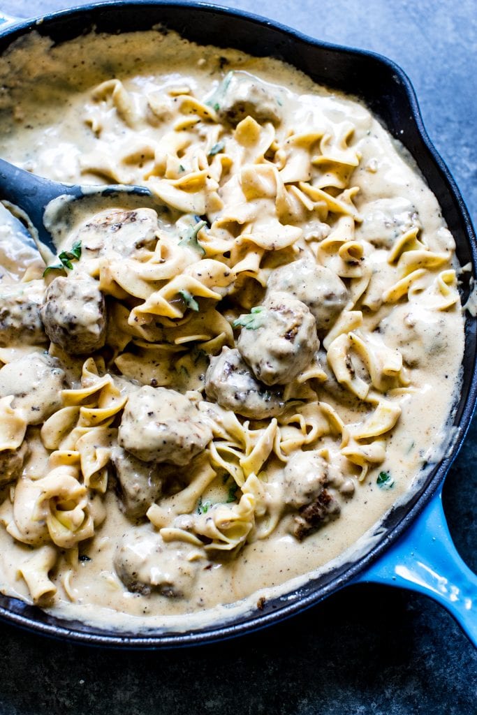 Swedish Meatballs in gravy in a cast iron skillet tossed with wide egg noodles