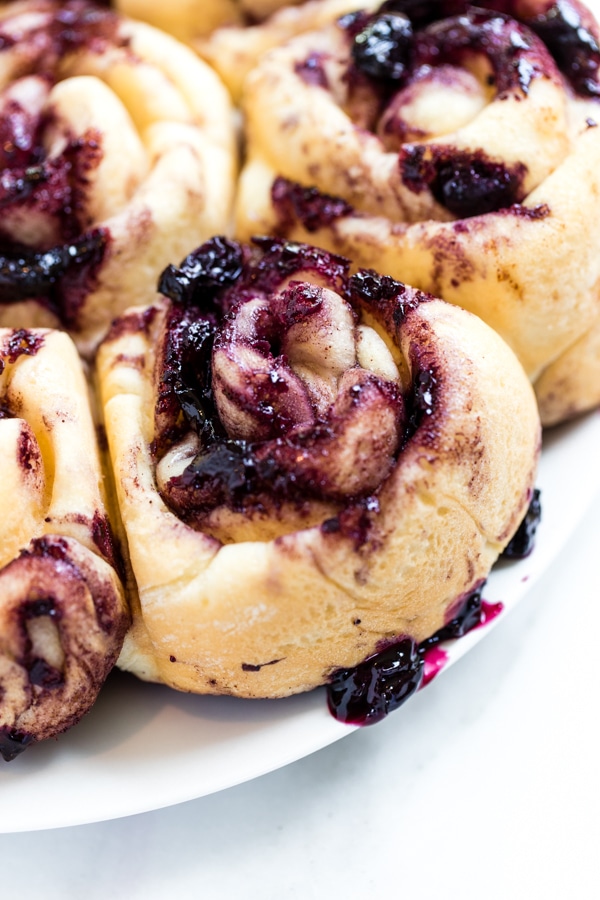 fresh homemade cinnamon rolls with blueberry sauce on top