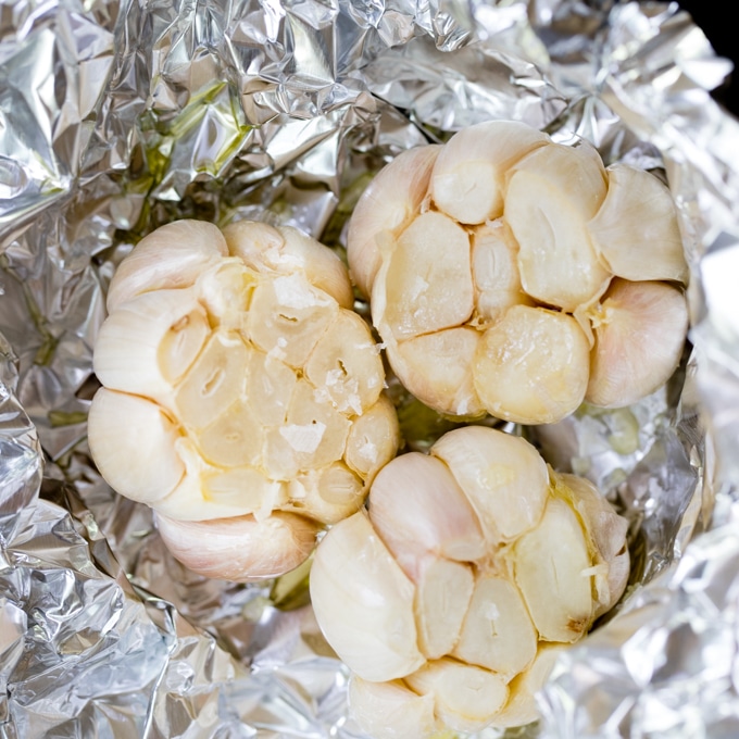 garlic about to be roasted in the oven, wrapped with foil and drizzled with olive oil