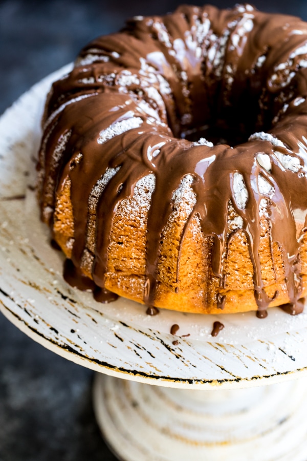 Bacardi rum cake on a cake stand with chocolate icing