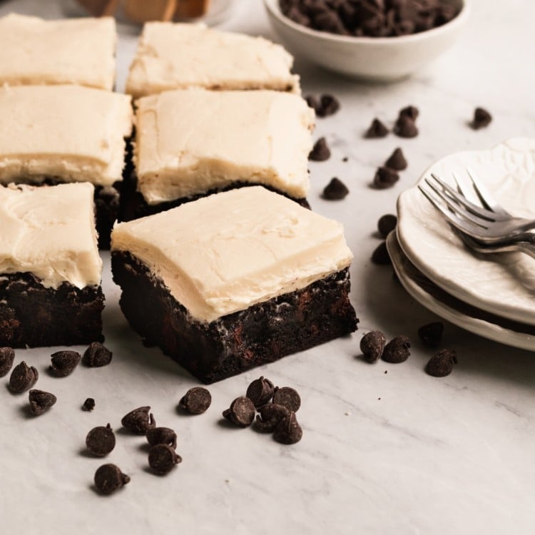brownies with buttercream frosting on a marble board