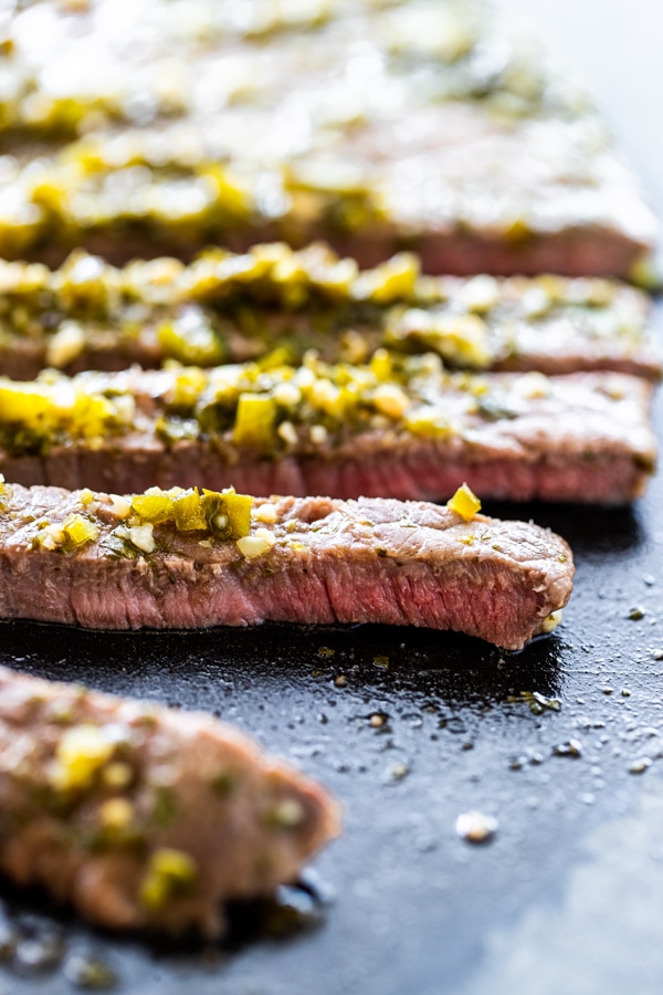 carne asada steak on a black cutting board