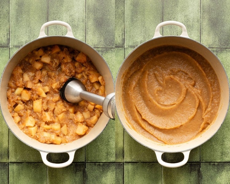 Apples cooking down in a large pot, partially mashed, with an immersion blender blending the mixture into smooth applesauce.