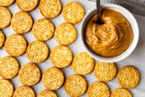 ritz crackers next to a bowl of peanut butter