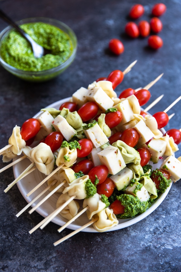 tortellini on a skewers with cherry tomatoes, jack cheese and spinach pesto