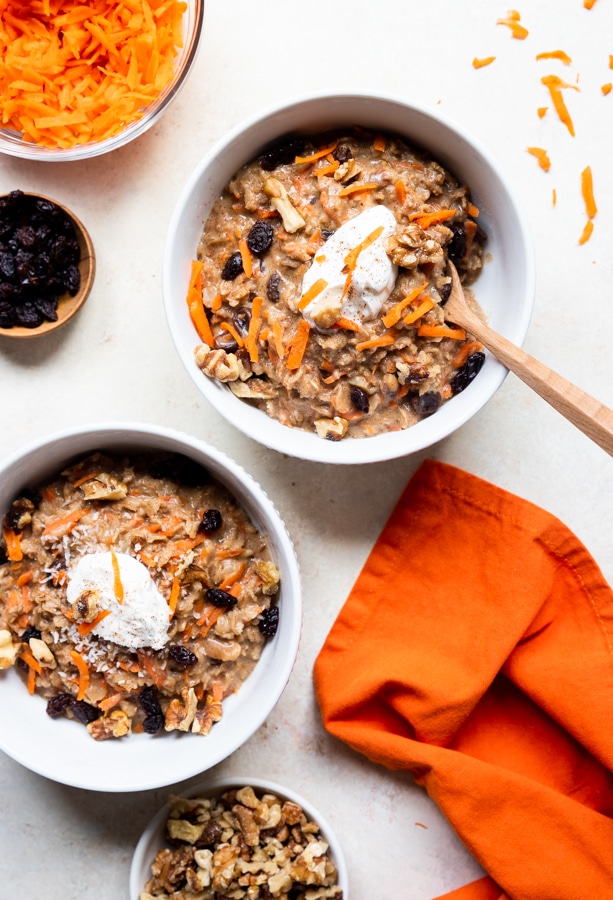 carrot cake oatmeal in white bowls topped with yogurt