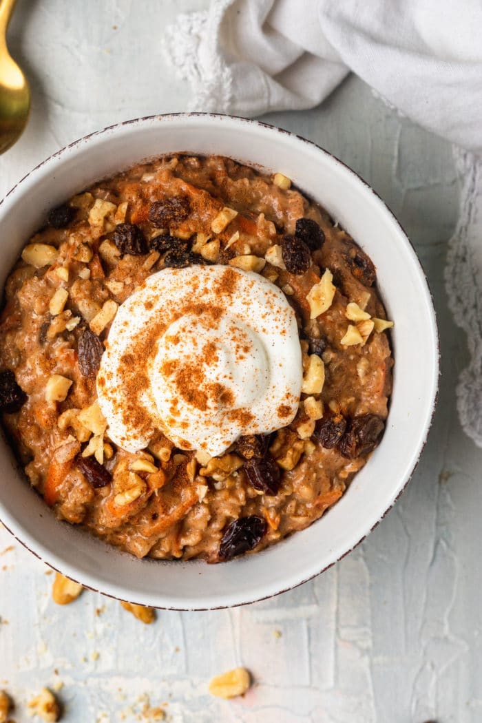carrot cake oatmeal in a bowl topped with Greek yogurt and cinnamon
