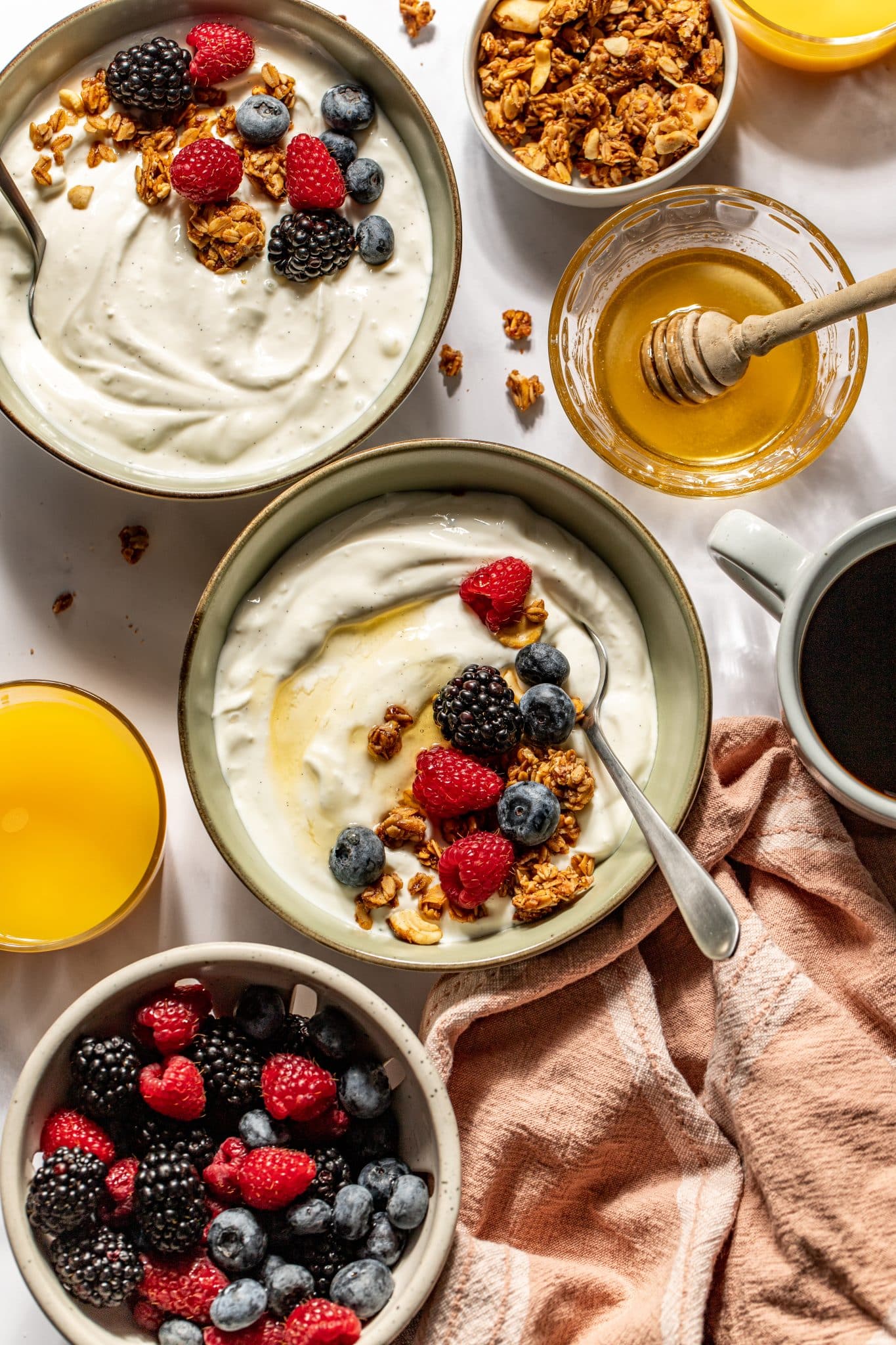 yogurt in bowls with honey and fresh berries on top. 