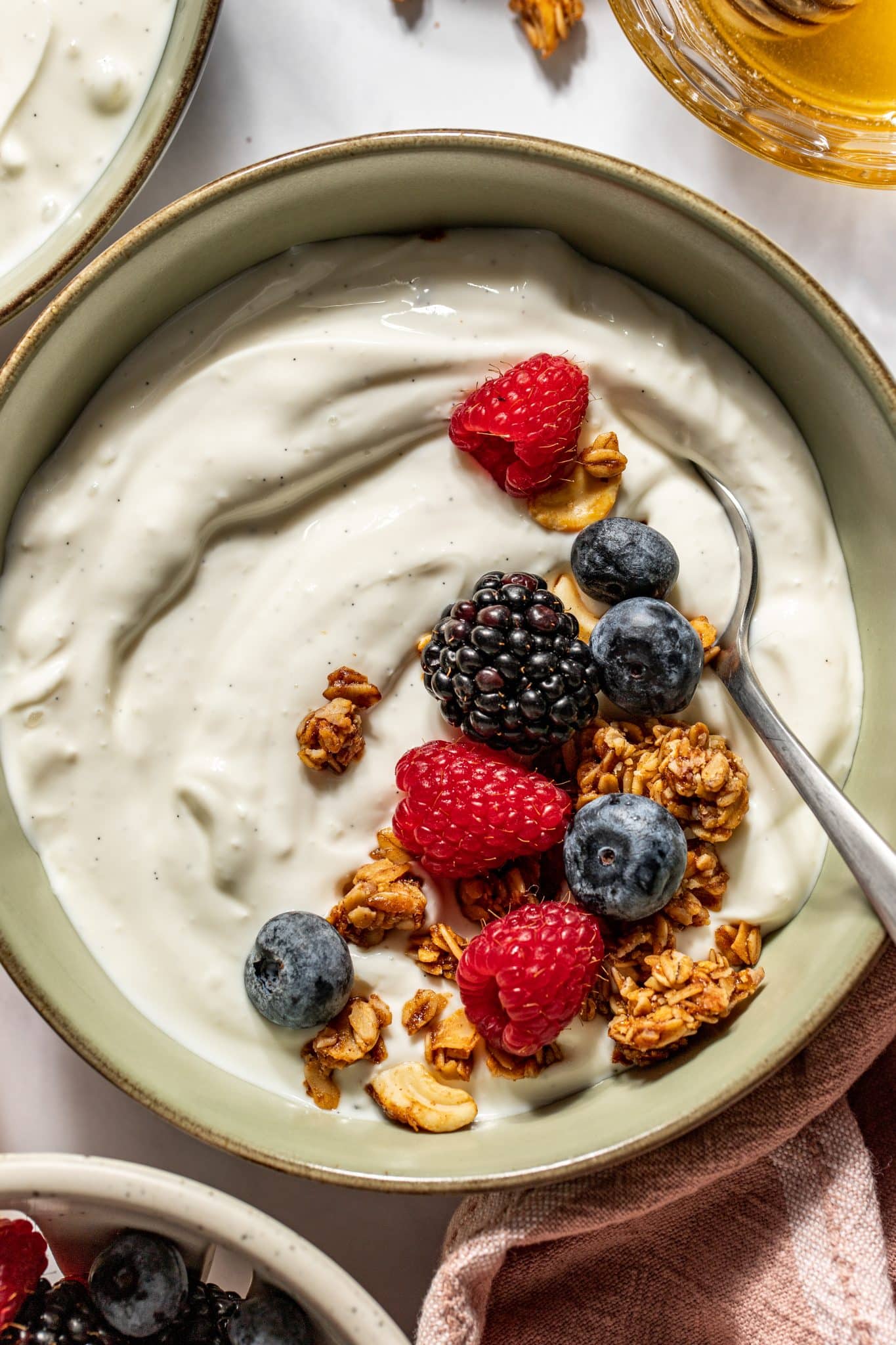 yogurt in a bowl with fresh berries and granola on top. 