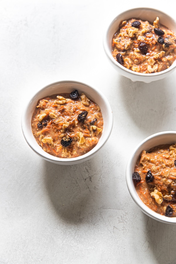 carrot cake oatmeal in white bowls topped with yogurt