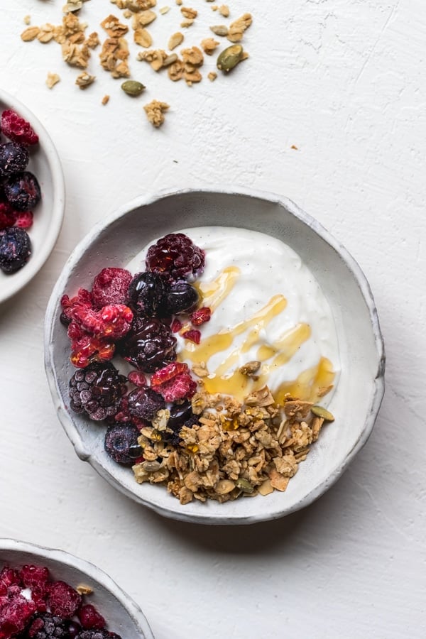 a white bowl filled with yogurt, berries and granola