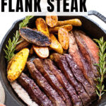 baked flank steak and fingerling potatoes in a cast iron skillet