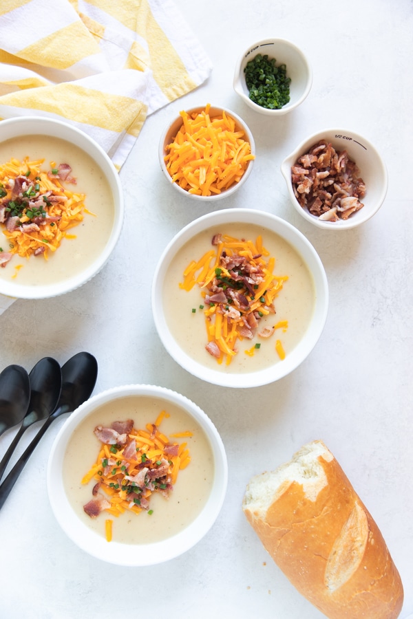 baked potato soup in white bowls with bacon