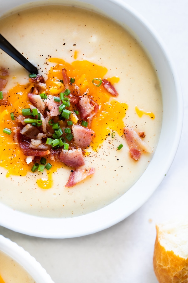 baked potato soup in white bowls with bacon