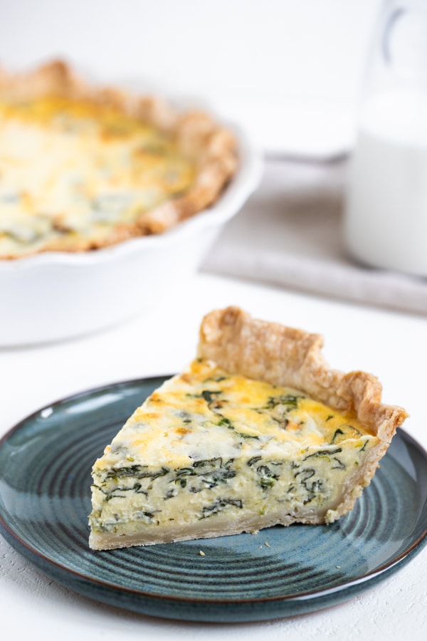 a slice of quiche Florentine on a blue plate
