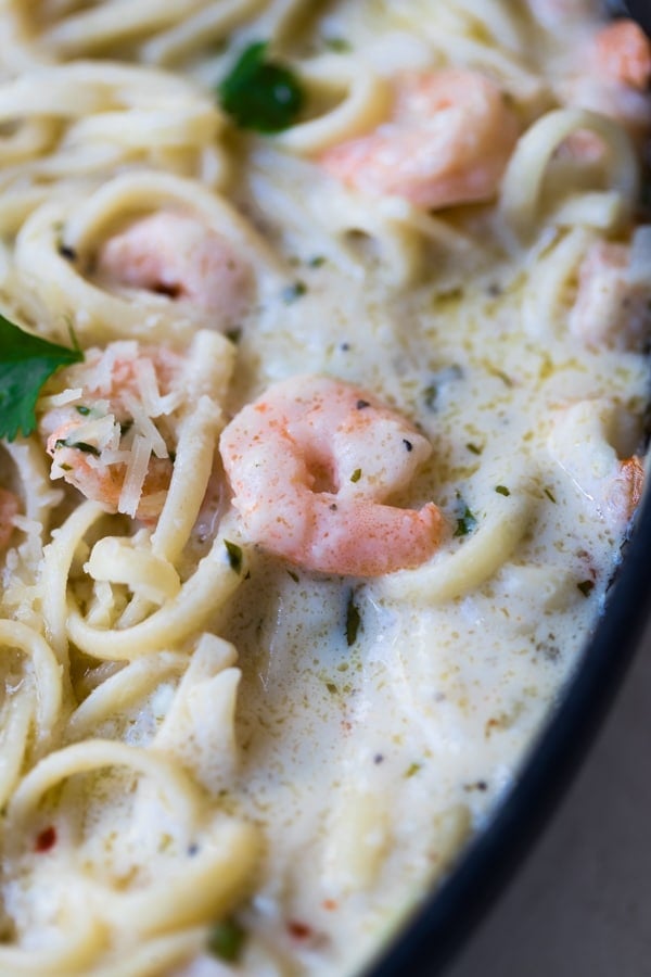 shrimp scampi in a large pan with parsley and parmesan cheese 
