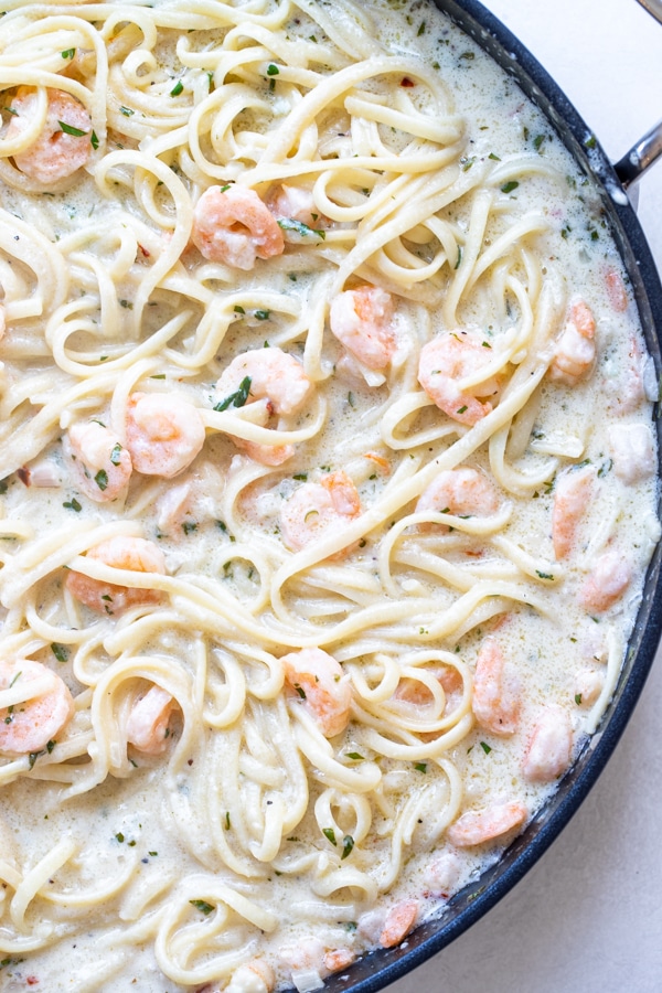 shrimp scampi in a large pan with parsley and parmesan cheese 