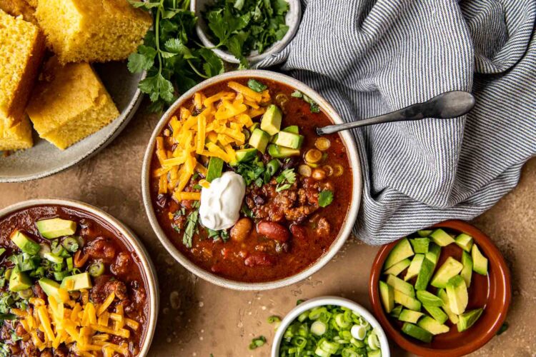 chili in a bowl with cheese and cornbread.