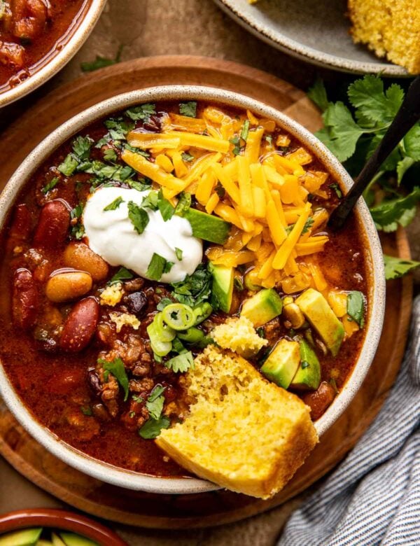 chili in a bowl with cheese and cornbread.