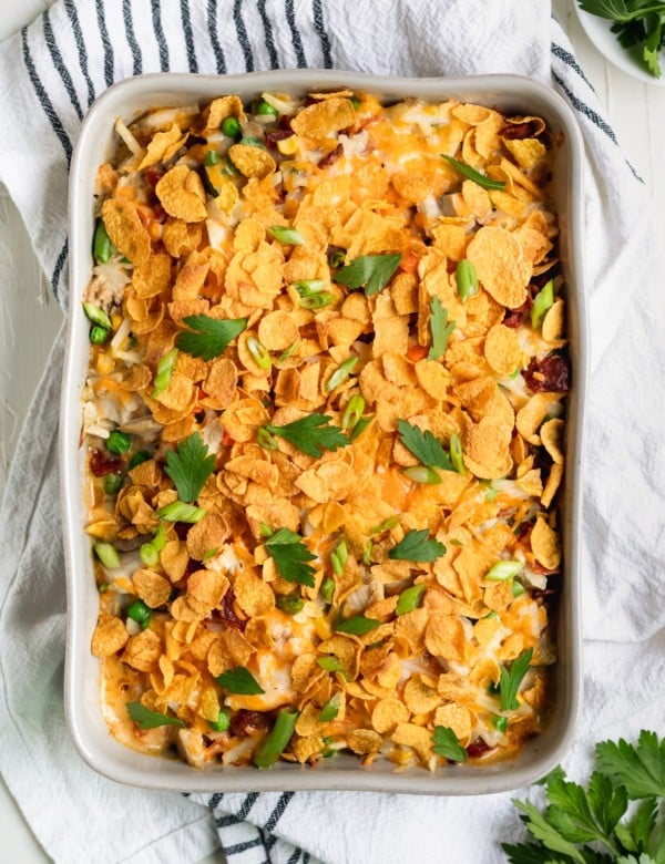 casserole in a casserole dish made with chicken and hash browns topped with cornflakes and fresh parsley