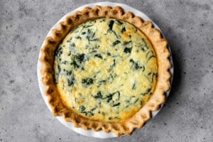 a pie dish full of spinach quiche