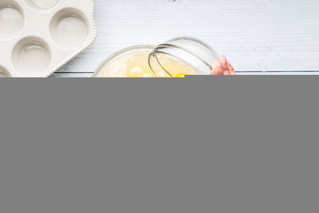 eggs being poured into a glass bowl