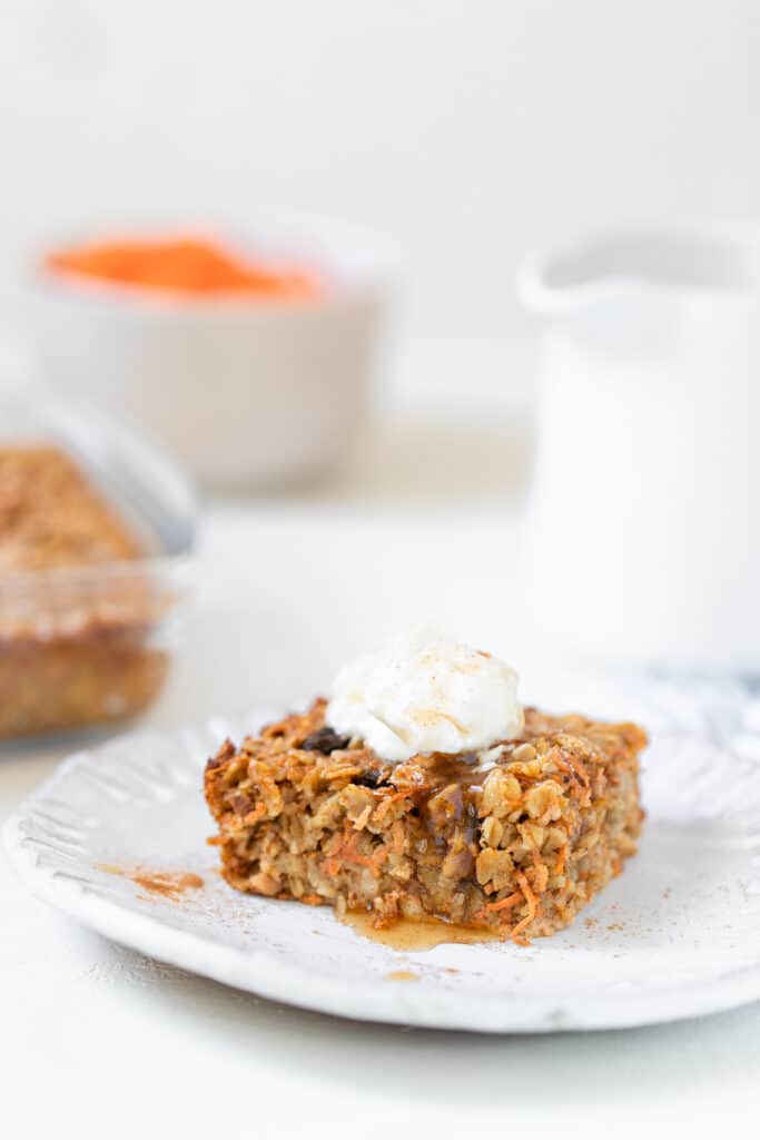 a slice of carrot cake oatmeal on a white plate