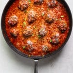 A close up of meatballs with red sauce in a skillet