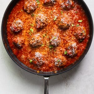 A close up of meatballs with red sauce in a skillet